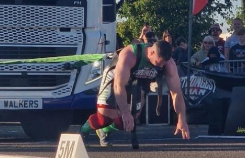 Man pulling truck with Freightlink banner behind at The UK Strongman 2024 Competition